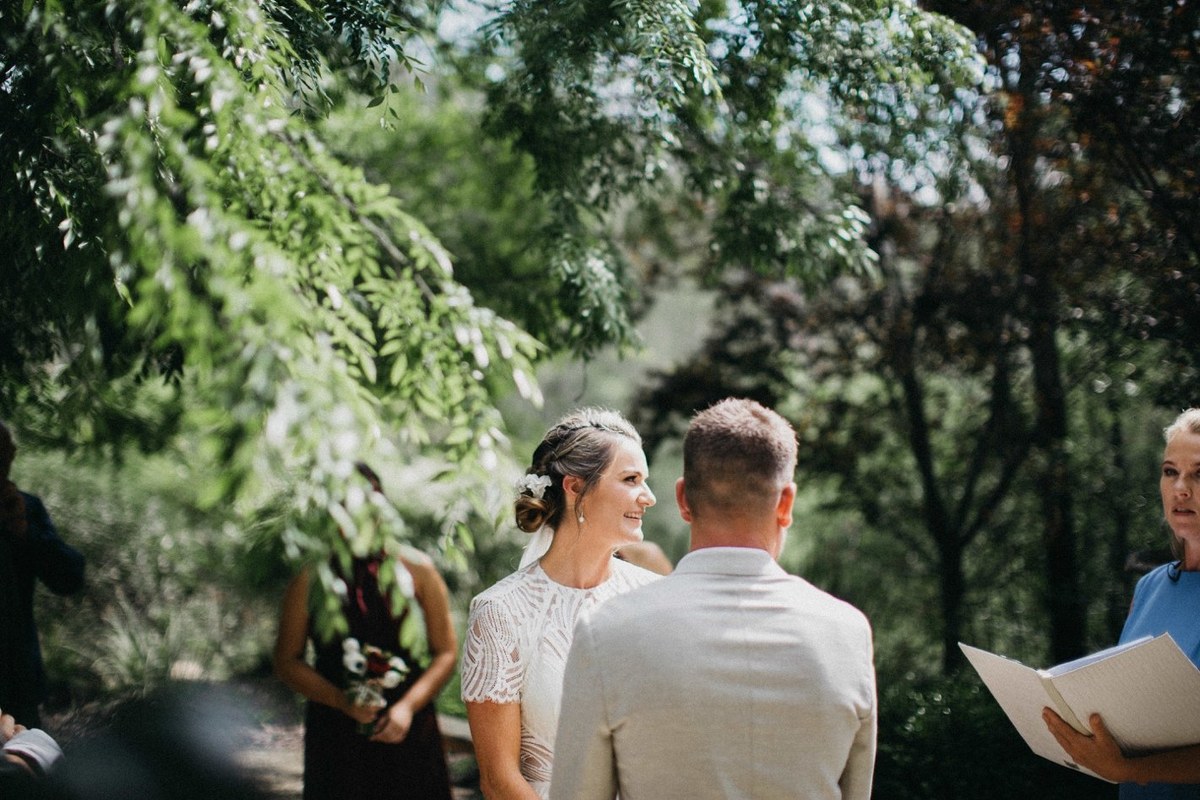 Bride arriving at Redleaf Wollombi — Joshua Mikhaiel, documentary wedding photographer The bride walks down the aisle toward the ceremony beneath the trees. Photograph by documentary wedding photographer Joshua Mikhaiel.
