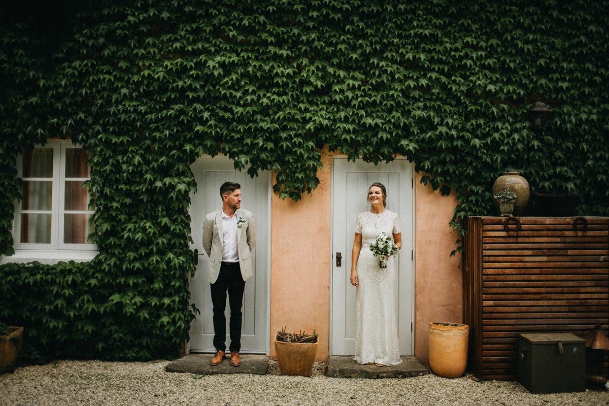 Newlyweds at Redleaf Wollombi — Joshua Mikhaiel, documentary wedding photographer The newlyweds pose together outside the ivy-covered homestead. Photograph by documentary wedding photographer Joshua Mikhaiel.