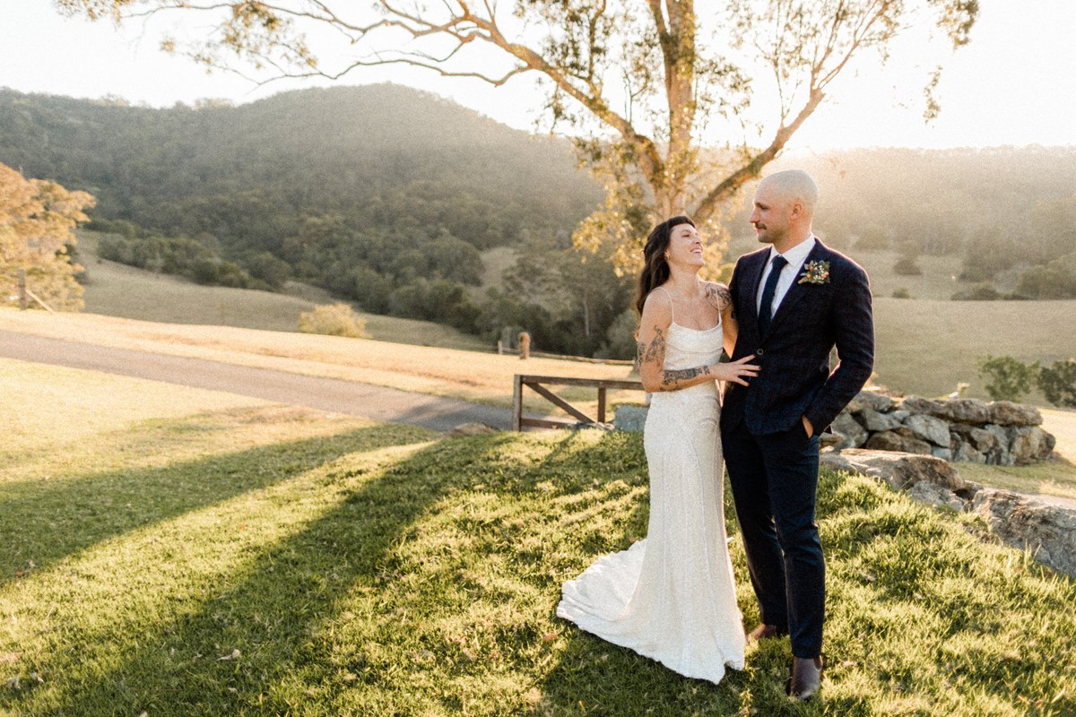 Cowbell Creek wedding portrait — Joshua Mikhaiel, documentary wedding photographer A bride and groom embrace on the lawn beneath the trees. Photograph by documentary wedding photographer Joshua Mikhaiel.