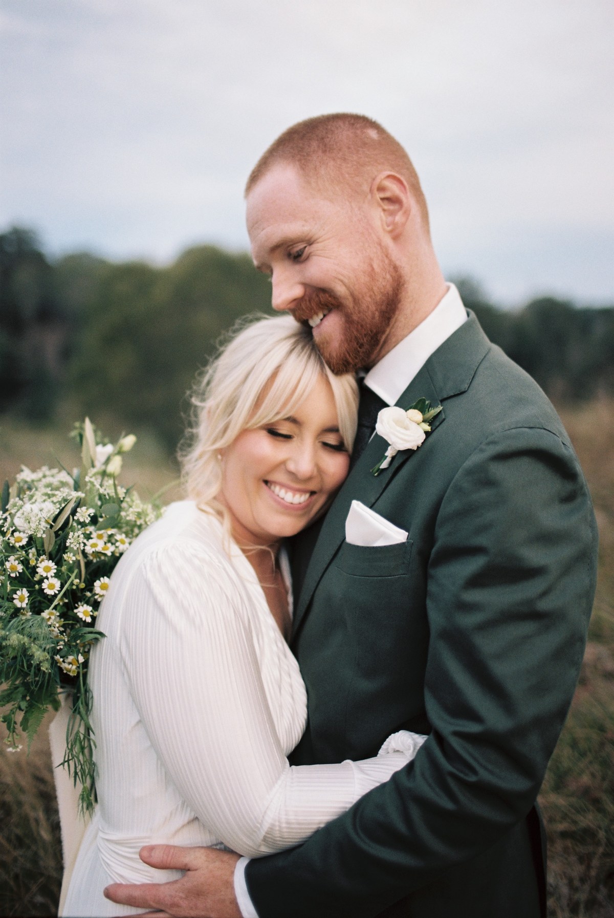 An intimate wedding portrait — Joshua Mikhaiel, documentary wedding photographer A smiling bride and groom hold one another close outdoors. Photograph by documentary wedding photographer Joshua Mikhaiel.