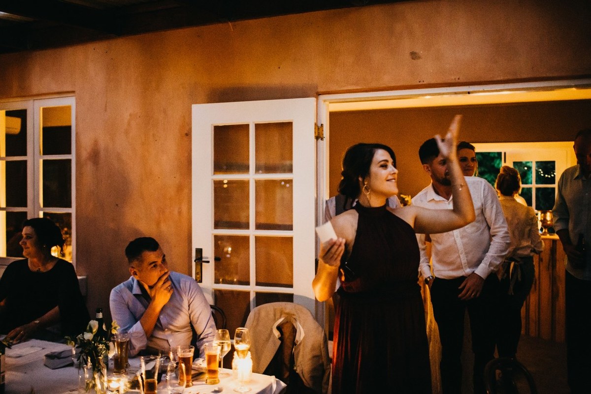 Guest speaking at Redleaf Wollombi — Joshua Mikhaiel, documentary wedding photographer A guest holds a microphone while seated guests listen. Photograph by documentary wedding photographer Joshua Mikhaiel.