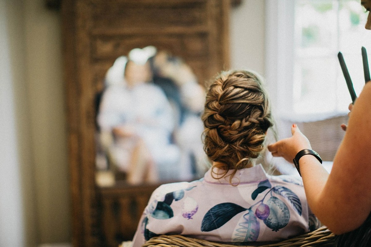Bride getting ready at Redleaf Wollombi — Joshua Mikhaiel, documentary wedding photographer An attendant styles the bride’s hair as she sits before the mirror. Photograph by documentary wedding photographer Joshua Mikhaiel.