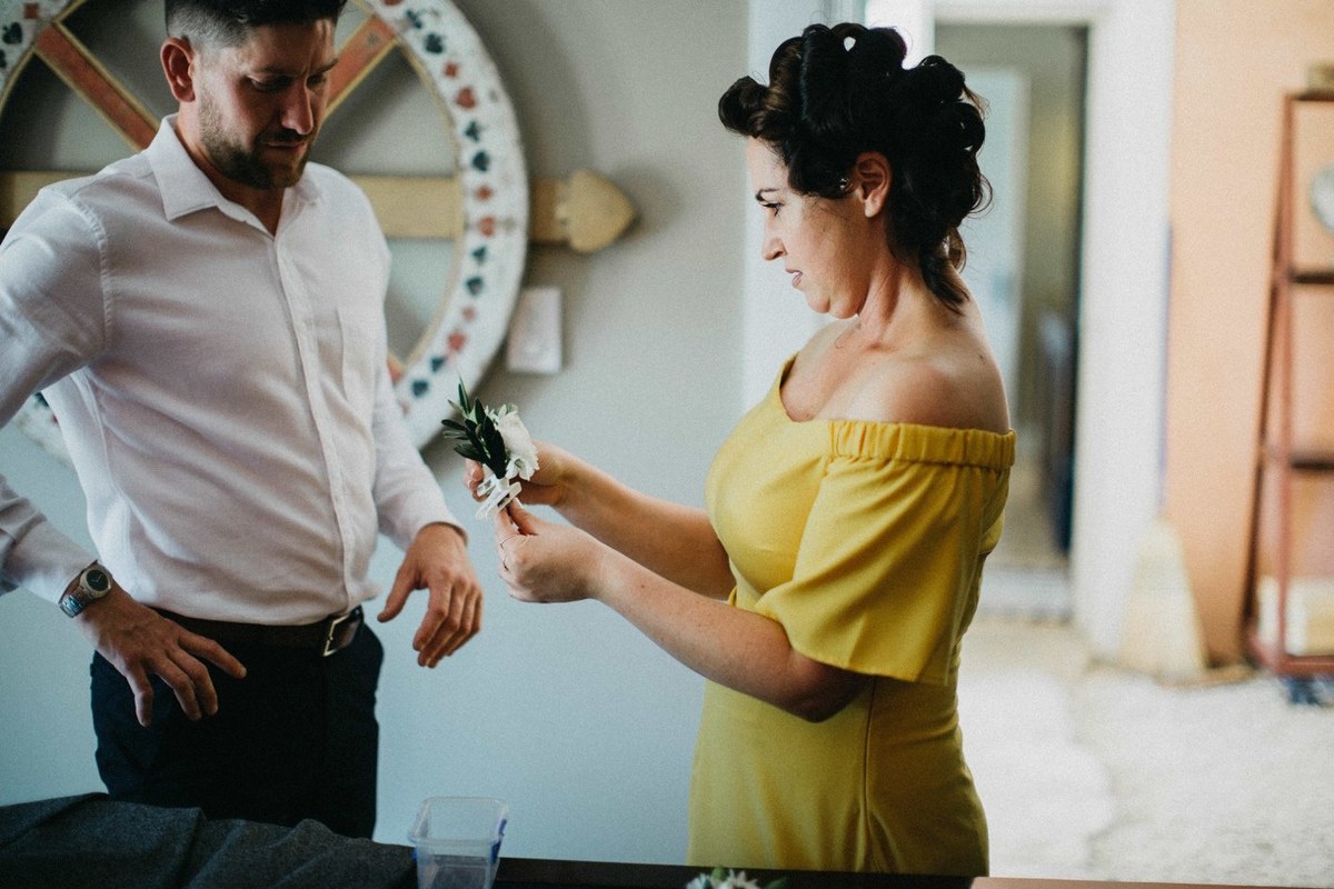 Wedding preparations at Redleaf Wollombi — Joshua Mikhaiel, documentary wedding photographer The groom helps a guest adjust her dress before the ceremony. Photograph by documentary wedding photographer Joshua Mikhaiel.