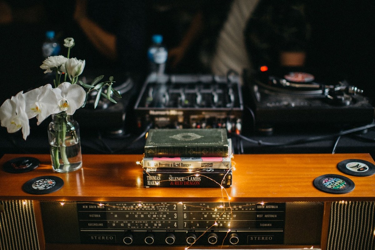 DJ booth at Redleaf Wollombi — Joshua Mikhaiel, documentary wedding photographer A DJ works behind a wooden booth with turntables and a laptop. Photograph by documentary wedding photographer Joshua Mikhaiel.