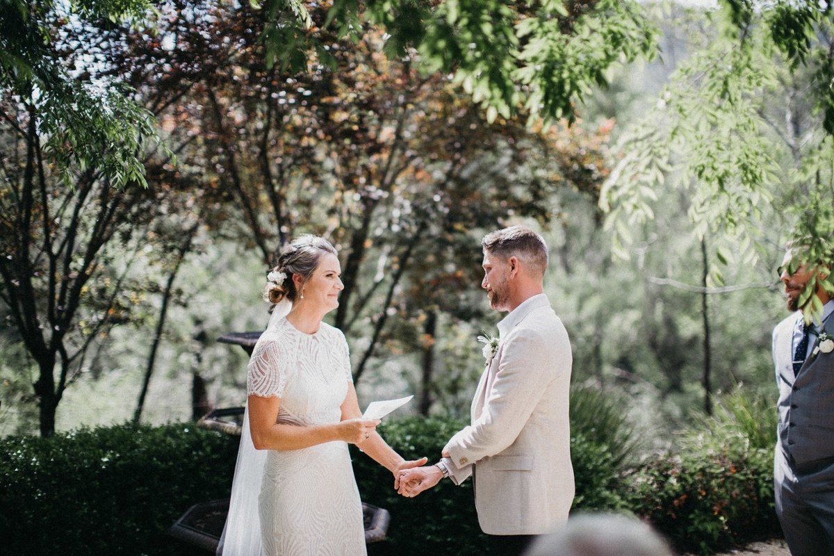 Wedding vows at Redleaf Wollombi — Joshua Mikhaiel, documentary wedding photographer The bride and groom hold hands during the ceremony as guests watch. Photograph by documentary wedding photographer Joshua Mikhaiel.