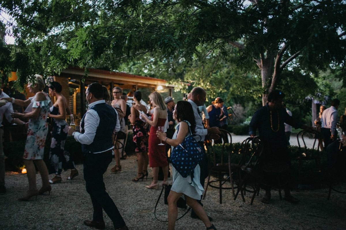 Guests at Redleaf Wollombi — Joshua Mikhaiel, documentary wedding photographer Guests mingle outdoors beside the reception building after dark. Photograph by documentary wedding photographer Joshua Mikhaiel.