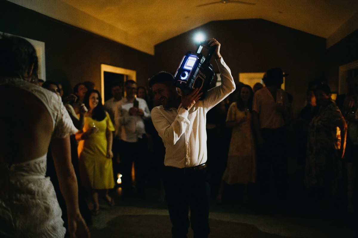 Wedding reception at Redleaf Wollombi — Joshua Mikhaiel, documentary wedding photographer Guests gather around the dance floor as a man speaks in two moments. Photograph by documentary wedding photographer Joshua Mikhaiel.