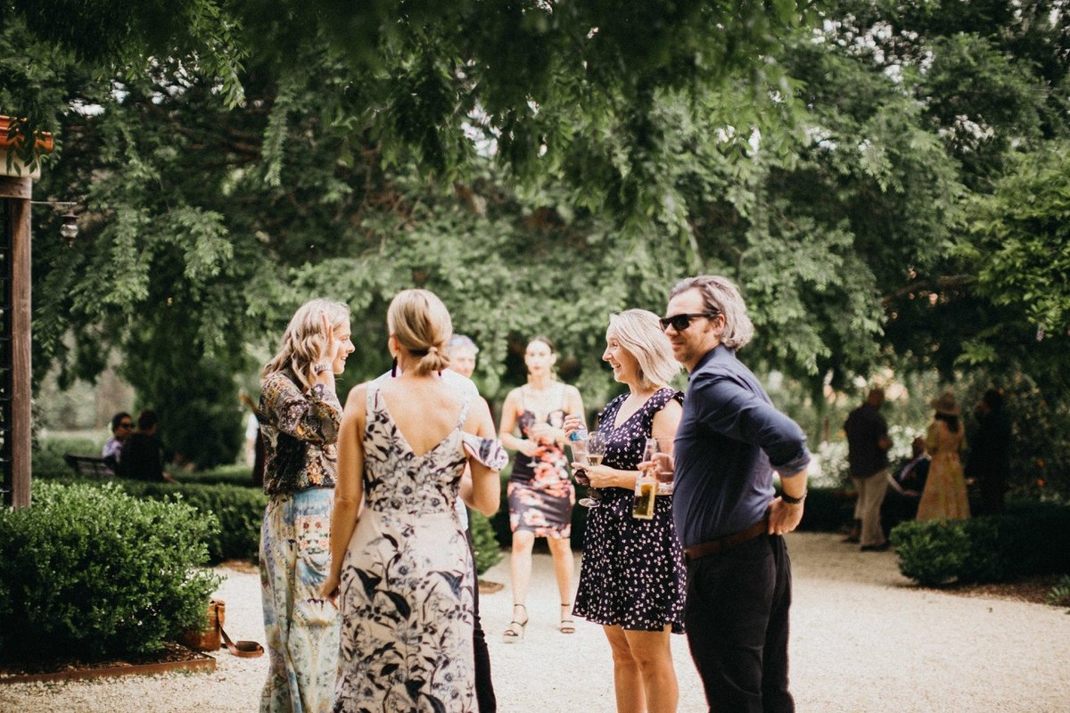 Wedding gathering at Redleaf Wollombi — Joshua Mikhaiel, documentary wedding photographer Guests mingle beneath the trees near the homestead. Photograph by documentary wedding photographer Joshua Mikhaiel.