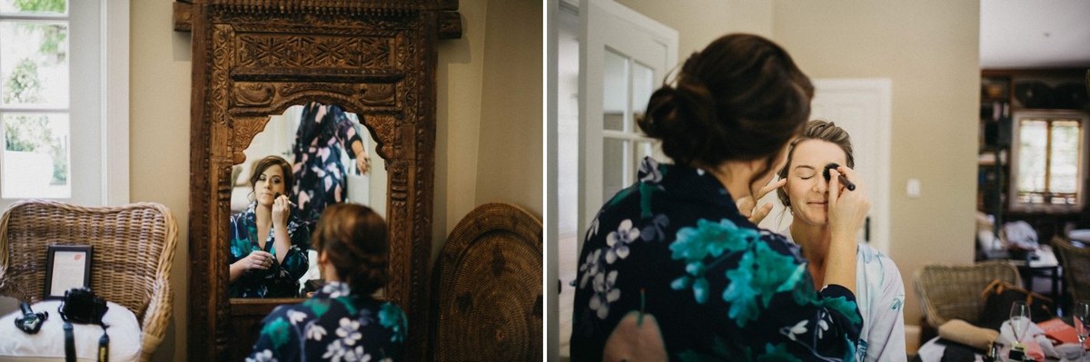 Bridal preparations at Redleaf Wollombi — Joshua Mikhaiel, documentary wedding photographer The bride gets ready before a mirror as an attendant works on her hair. Photograph by documentary wedding photographer Joshua Mikhaiel.