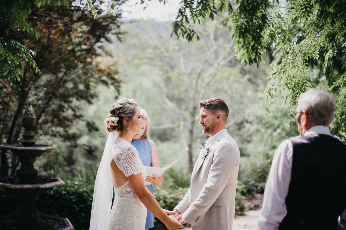 Wedding ceremony at Redleaf Wollombi — Joshua Mikhaiel, documentary wedding photographer The bride and an older guest hold hands as another guest looks on. Photograph by documentary wedding photographer Joshua Mikhaiel.