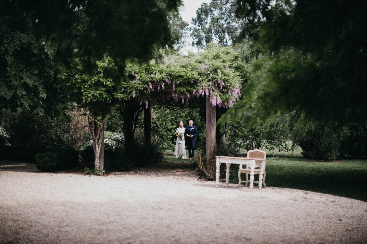 Wedding party at Redleaf Wollombi — Joshua Mikhaiel, documentary wedding photographer The bride and groom pose with a guest in the garden. Photograph by documentary wedding photographer Joshua Mikhaiel.